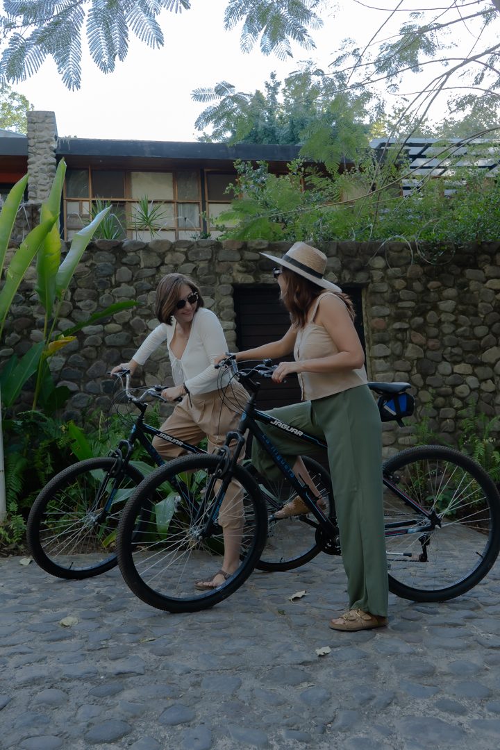 Dos huéspedes en bicicleta saliendo del hotel hacia las calles empedradas de Comala
