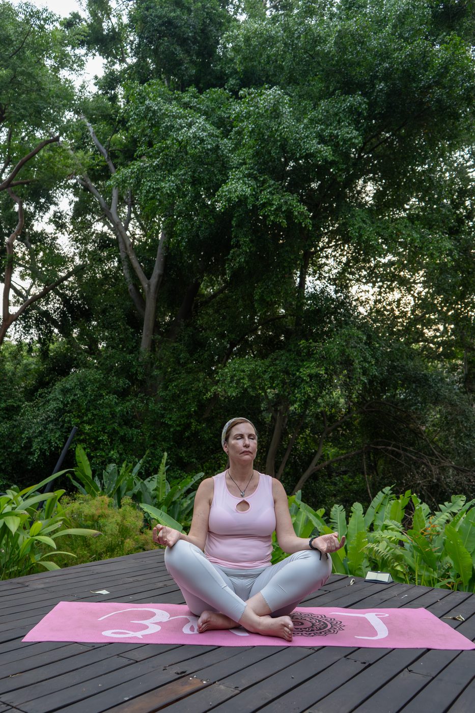 Práctica de yoga sobre deck en el jardín